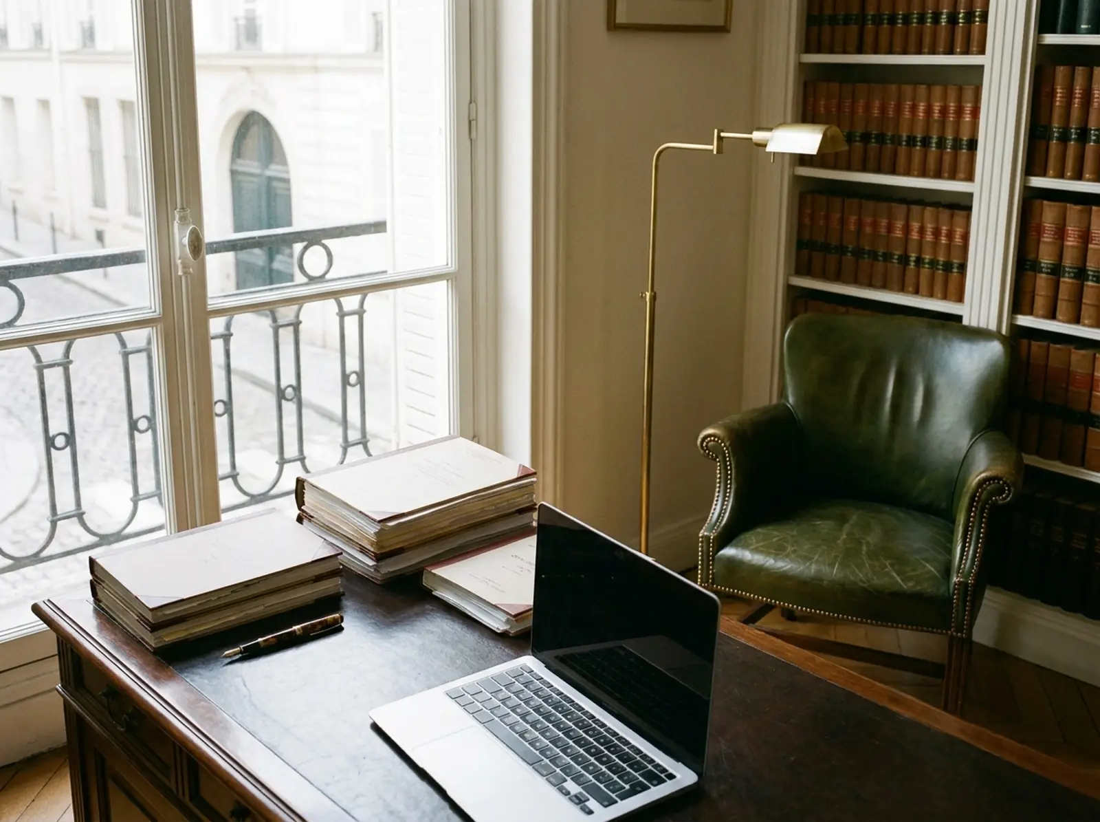 Bureau d’avocat parisien avec dossiers, stylo plume et bibliothèque juridique